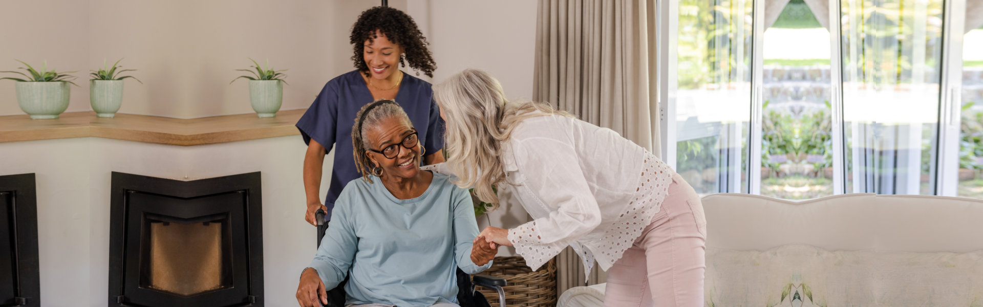 Caregiver assisting elderly woman in wheelchair